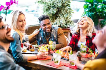 Young friends drinking mojito cocktails at fancy pub restaurant - Life style concept with...