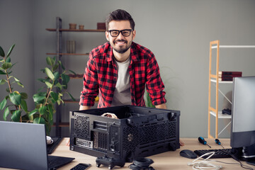 Portrait of attractive smart bearded cheerful trendy guy upgrading processor data tech issue at...