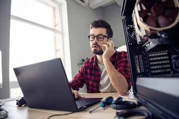 Portrait of attractive smart skilled trendy guy contacting client debugging data code at office...