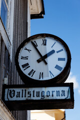 Fototapeta na wymiar Nordmaling, Norrland Sweden - July 21, 2021: old clock and sign with the text: - meadow cottages