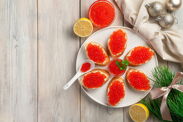 Sandwiches with red caviar, butter and fresh parsley on a Christmas background.