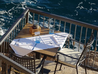 Gedeckter Tisch über dem Meer wartet auf seine Gäste