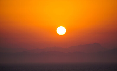 Golden sun in the morning, image of a sunrise with mountains and sea in the background