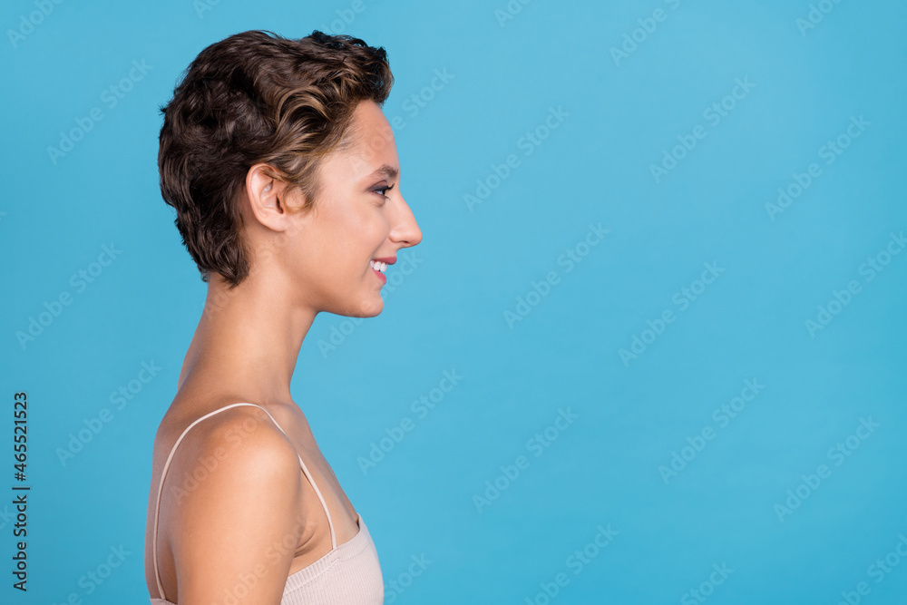 Wall mural Photo of sweet pretty young woman dressed beige top looking empty space smiling isolated blue color background