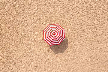 Striped beach umbrella on sandy coast, aerial view © New Africa