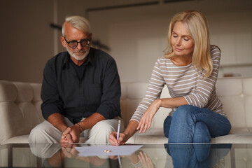 Mature couple signing divorce document. Senior family separation, problems between husband and...