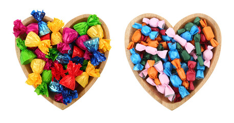Heart shaped plate with candies in colorful wrappers on white background, top view