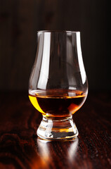 glass of whisky spirit brandy on dark brown background