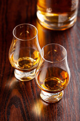 Bottle and glass of whisky spirit brandy on dark brown background