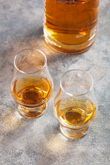 glass and bottle of whisky spirit brandy on gray concrete background