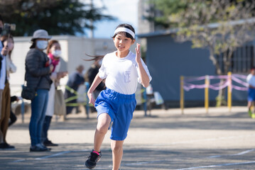 運動会で徒競走を走る小学生の女の子