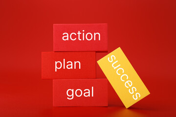Success formula or strategy concept in red colors. Goal, plan, action written on red and yellow...
