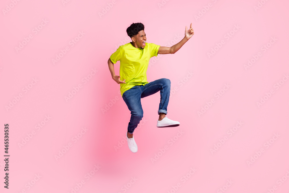 Wall mural Full size profile side photo of young african guy unhappy angry conflict jump up isolated over pink color background