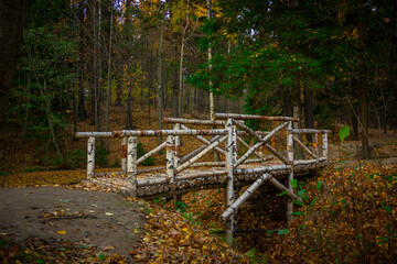 a wooden bridge in an autumn park made of birch trunks and planks