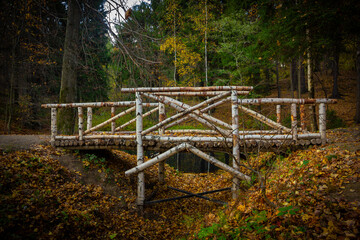 a wooden bridge in an autumn park made of birch trunks and planks