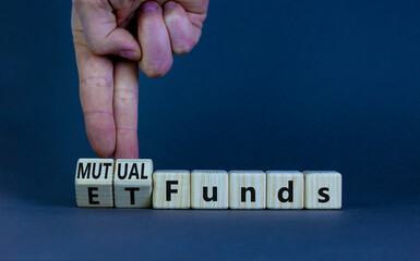 Mutual funds vs ETF symbol. Businessman turns cubes and changes words 'ETF, Exchange-Traded Fund'...
