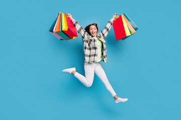 Full size photo of young excited girl happy positive smile jump hold shopping bags isolated over...