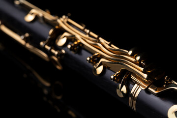 Naklejka premium Part of a clarinet with gold plated keys on a black background. A woodwind instrument common to classical music.