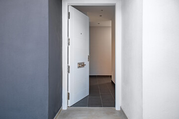 Open white door to the corridor of the house