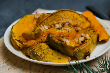 Baked pumpkin with provencal herbs and walnuts. Seasonal healthy vegetarian autumn Thanksgiving meal.