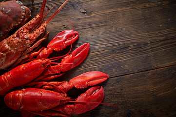 Boiled red Lobsters, crab and crawfish on wooden background. Seafood with copy space