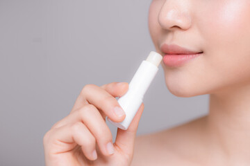 Woman With Beauty Face Applying Lip Balm.
