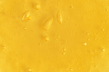 Texture of transparent yellow antiseptic gel with air bubbles on light monochrome background. Concept of skin moisturizing and prevention of virus. Liquid beauty product closeup. Backdrop, flat lay