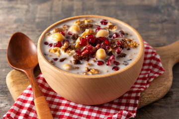 Traditional Turkish Noah's pudding in bowl on wooden table