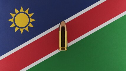 Top down view of a 9mm bullet in the center and on top of the flag of Namibia