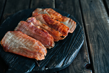 Dried chicken cut into slices on a wooden board. High quality photo