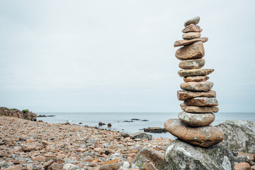 Balancing stones on the rocky coast of Hovs Hallar nature reserve in Sweden. Blurred background. Selective focus.