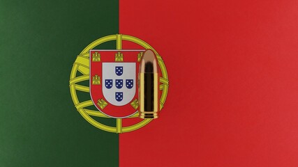 Top down view of a 9mm bullet in the center and on top of the flag of Portugal