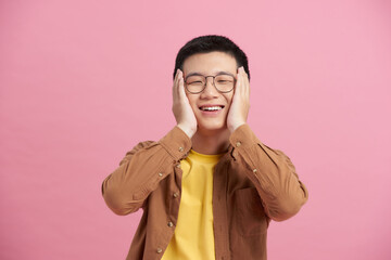 Happy and amazed asian young man touching his face, shocked with unexpected promotion at work