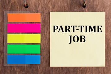 a card with Part-time JOB on a wooden background next to colored stickers