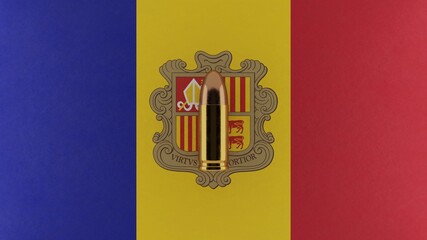 Top down view of a 9mm bullet in the center and on top of the flag of Andorra