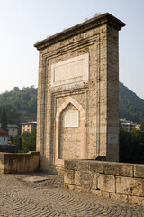 Fototapeta na wymiar The pile with laudatory inscriptions on the Mehmed Pasha Sokolovic bridge in Visegrad, Bosnia and Herzegovina