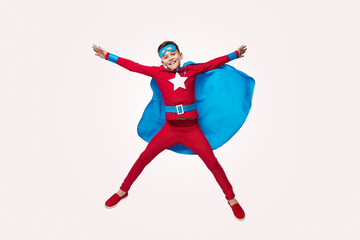 Cheerful superhero jumping with outstretched arms