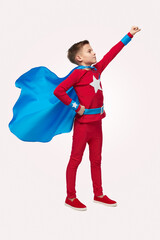 Fearless boy in superhero costume in studio
