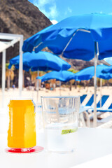 Fototapeta na wymiar Glass and cane of a soda drink on a beach bar table, in Tenerife. Canary Islands.