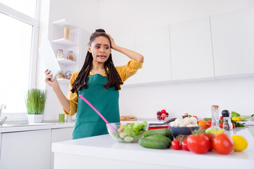 Photo of upset shocked dark skin lady wear yellow shirt cooking holding modern device indoors room home house