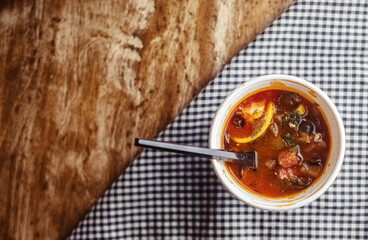 Close-up of a hodgepodge in a disposable paper cup. The concept of traditional food and foreign cuisine. Safe eco-friendly disposable tableware.