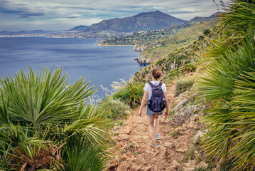 Tourist on a trail in Zingaro natural reserve on the shore of Castellammare Gulf on Sicily Island,...