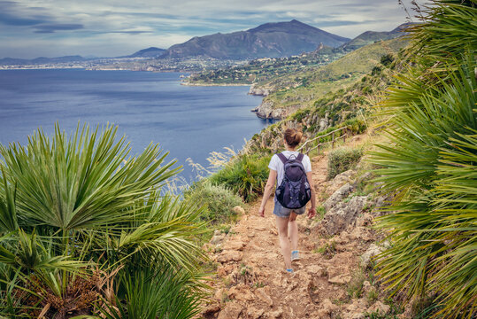 Tourist on a trail in Zingaro natural reserve on the shore of Castellammare Gulf on Sicily Island, Italy