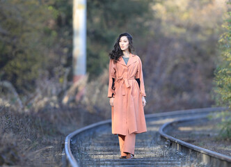 Autumn portrait of Fashion model on railway rails