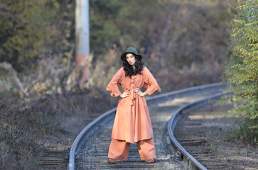 Autumn portrait of Fashion model on railway rails