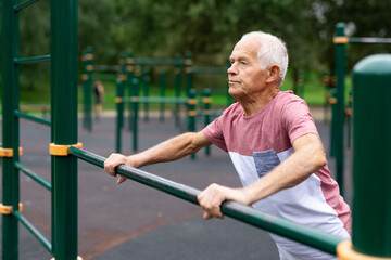 Sportive elderly man training on outdoor sports ground