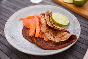 salted salmon fillet with rye pancakes and lime