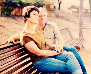 elderly man and woman embracing on bench