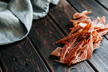 Dried chicken cut into strips on a wooden board with salt, pepper, adjiga, ketchup. High quality photo