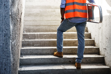 Professional builder carrying metal ladder, close up